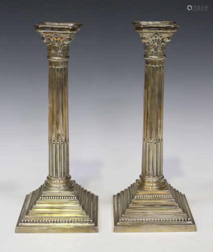 A pair of George V silver Corinthian column candlesticks, each with detachable nozzle, on a
