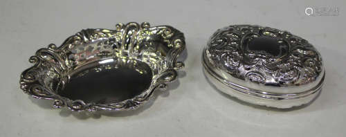 A late Victorian silver oval shaped box with hinged lid, with overall embossed foliate decoration