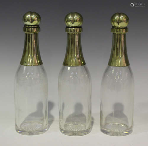 A set of three late Victorian plate mounted clear glass novelty liquor decanters and stoppers,