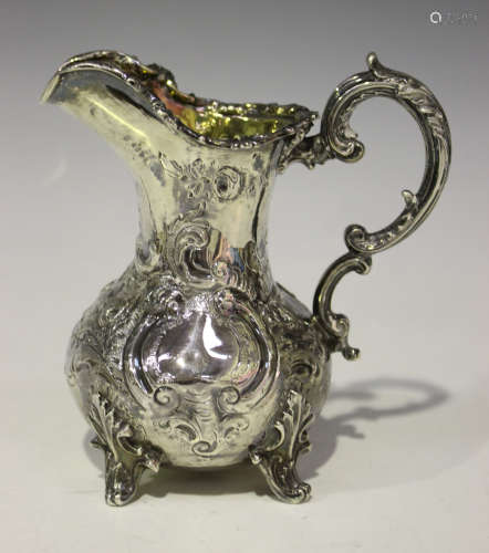 A Victorian silver baluster cream jug with foliate and reeded scroll handle, decorated in relief