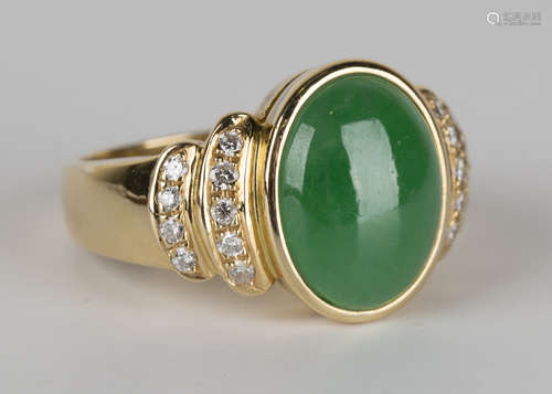 A gold, jade and diamond ring, collet set with the oval cabochon jade between diamond set curved