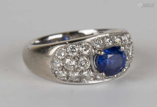 A white gold, sapphire and diamond ring, claw set with the oval cut sapphire within a bombé