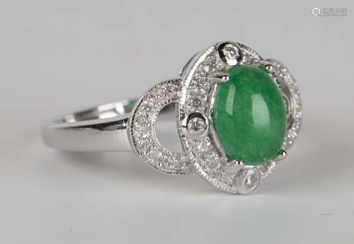 A white gold, jade and diamond ring, claw set with an oval cabochon jade within a surround of