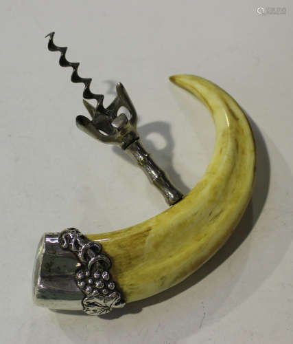 A late 19th century American sterling mounted boar tusk handled corkscrew, the end mount decorated