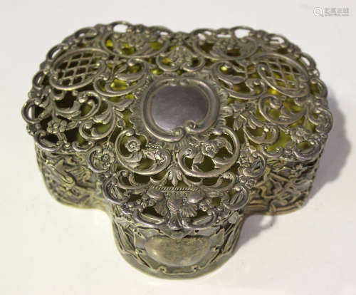 An Edwardian silver serpentine shaped jewellery box, the hinged lid pierced and cast with flowers,