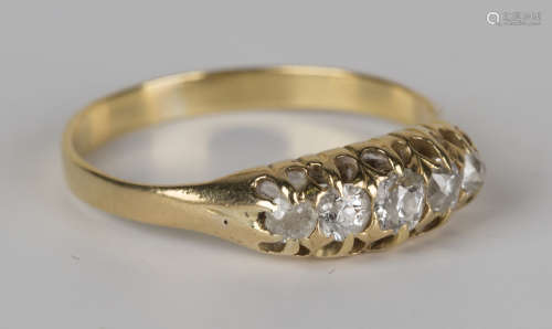 A gold and diamond five stone ring, mounted with a row of cushion shaped diamonds graduating in size
