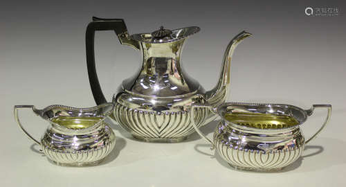 An Edwardian silver three-piece coffee set, each piece of half-reeded cushion form, comprising