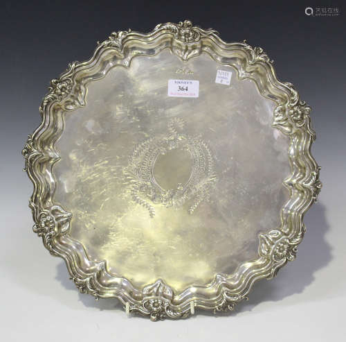 An Edwardian silver salver with foliate and scroll rim framing an engraved vacant cartouche,