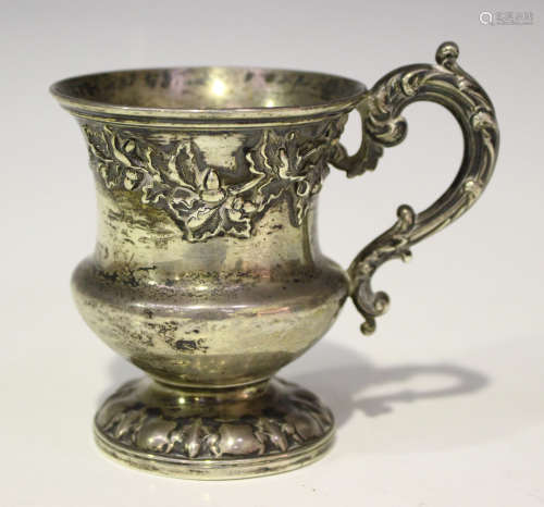 A William IV silver christening mug, the flared neck decorated with acorns and oak leaves, flanked