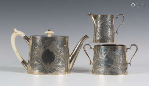 A late Victorian silver three-piece tea set, each slightly tapered oval body engraved with ferns and