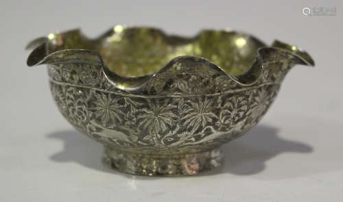 A late 19th century Indian white metal bowl, decorated in relief with animals, palm trees and