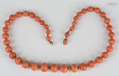 A single row necklace of forty graduated coral beads alternating with forty-one smaller graduated