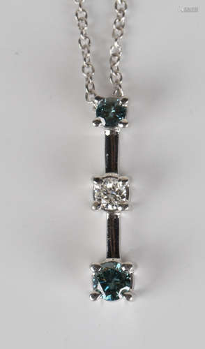 A white gold, treated blue diamond and white diamond three stone pendant, claw set with a row of