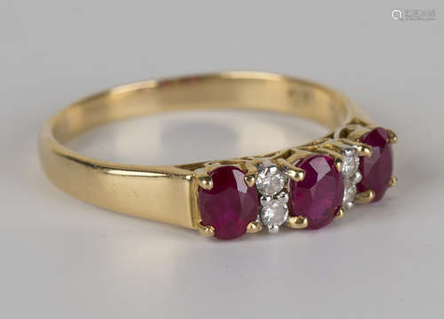 A gold, ruby and diamond ring, claw set with three oval cut rubies alternating with two pairs of