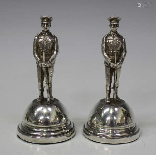 A pair of George V silver mounted menu holders, each domed base surmounted with the figure of a