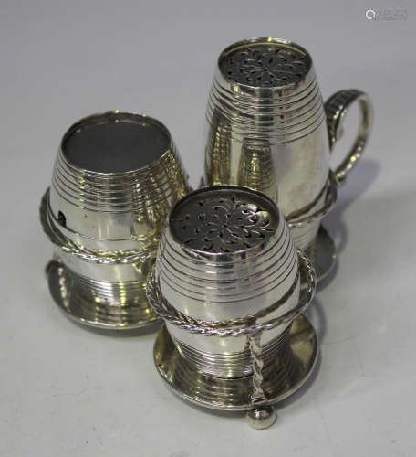 A Victorian silver three-piece condiment set and stand, the triform stand with scroll handle