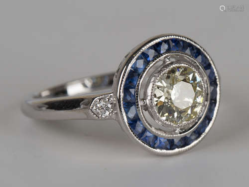 An 18ct white gold, diamond and sapphire ring, collet set with the principal circular cut diamond