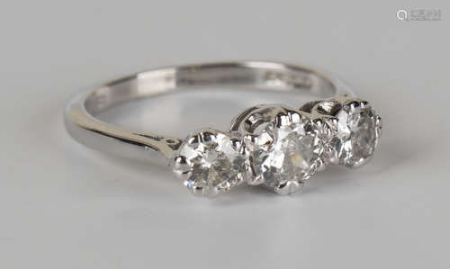 An 18ct white gold and diamond three stone ring, claw set with circular cut diamonds, ring size