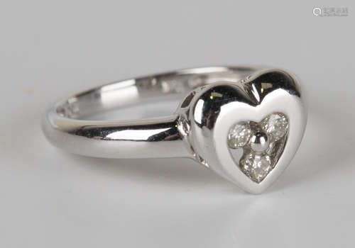 A white gold and diamond ring in an open heart shaped design, mounted with three circular cut