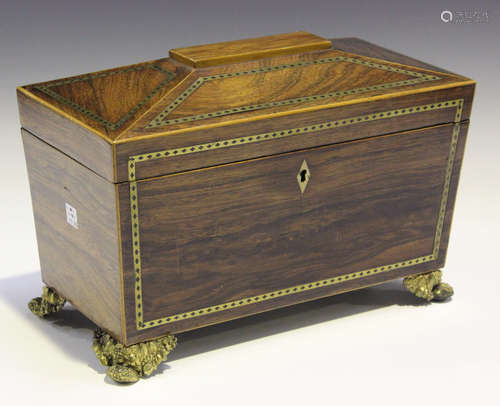 A Regency rosewood and brass inlaid sarcophagus tea caddy, raised on pressed gilt brass feet,