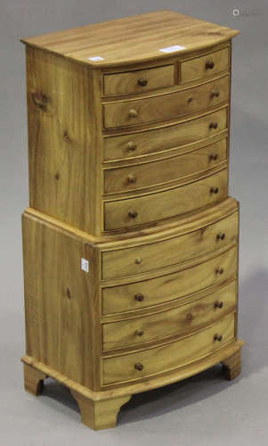 A modern diminutive hardwood chest-on-chest, fitted with two short and eight long drawers, on