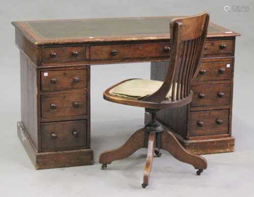A Victorian mahogany and stained pine twin pedestal desk, fitted with nine drawers, on plinth bases,