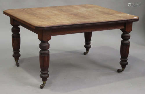 A late Victorian walnut extending dining table with two extra leaves, raised on turned and fluted