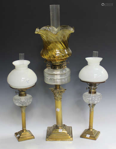 A pair of late Victorian brass and cut glass table oil lamps with Corinthian column supports, fitted