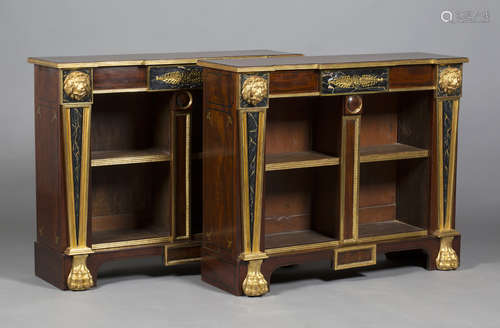 A pair of Empire style mahogany inverted breakfront bookcases with overall gilded decoration, the