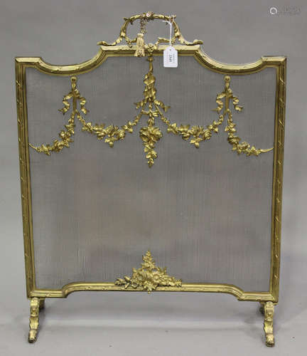 An early 20th century gilt metal and mesh firescreen with applied floral swag mounts, height 80cm,