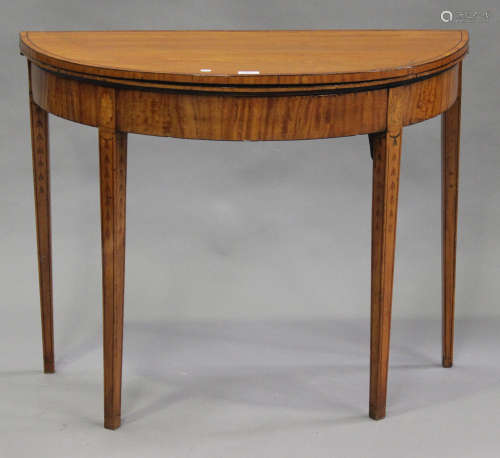 A George III satinwood demi-lune fold-over card table with inlaid decoration, on square tapering