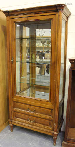 A late 20th century French cherry vitrine with mirrored back, the glazed door revealing shelves