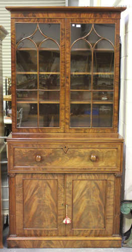 A William IV figured mahogany secrétaire bookcase cabinet, the moulded pediment above a pair of