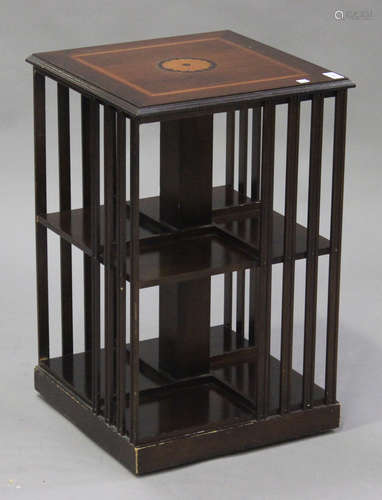 A 20th century reproduction mahogany revolving bookcase with inlaid decoration, raised on castors,