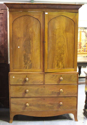 A Victorian mahogany linen press, the moulded pediment above a pair of panel doors revealing sliding