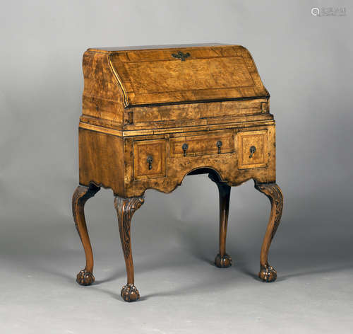 An early 20th century Queen Anne style walnut bureau, the fall front revealing a writing surface and