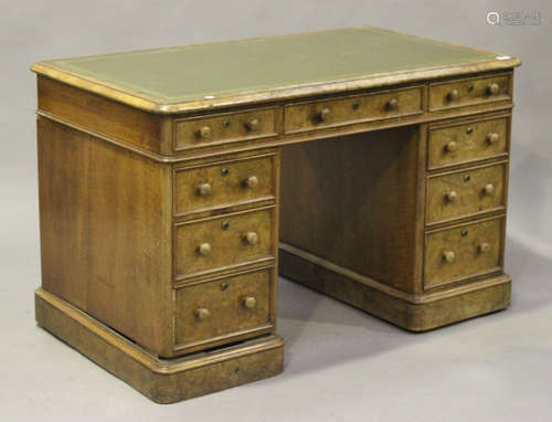 A mid-Victorian burr walnut twin pedestal desk, the moulded top inset with gilt-tooled green leather