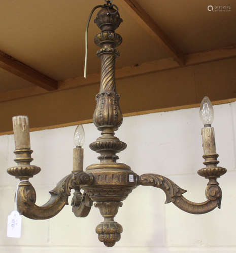 A late 19th/early 20th century giltwood three light chandelier with carved scrolling branches,