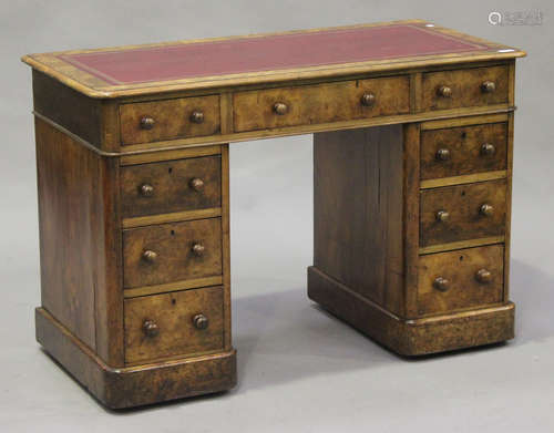 A mid-Victorian burr walnut twin pedestal desk, the moulded top inset with a red gilt-tooled leather