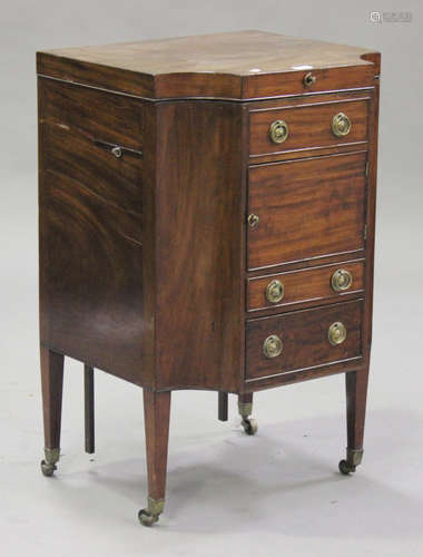 A George III mahogany gentleman's washstand, the hinged top above drawers and cupboards, raised on