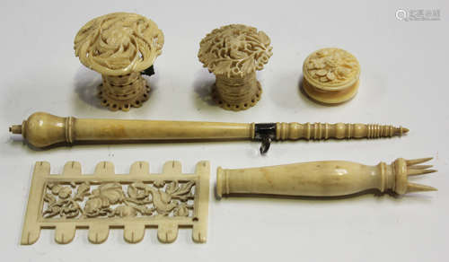 A group of 19th century carved ivory needlework implements, including two tape measures and a thread