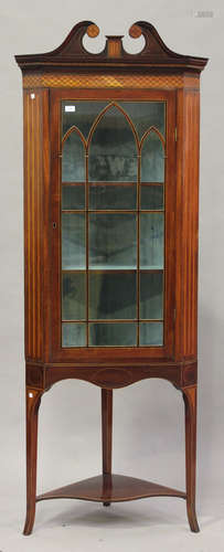 A George III mahogany and inlaid corner display cabinet, the swan neck moulded pediment above an