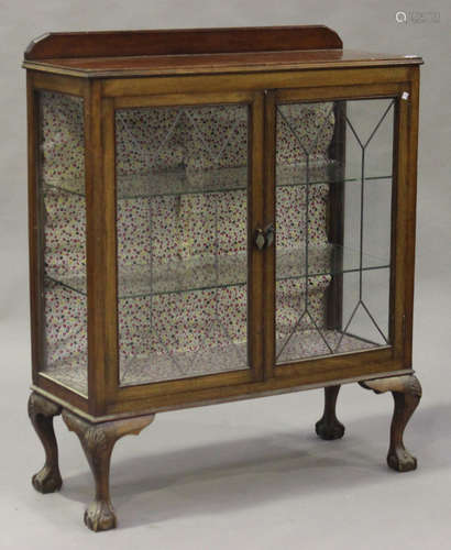 An early 20th century mahogany display cabinet with leaded glass doors, on cabriole legs and claw