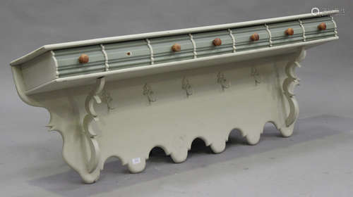 A 20th century painted pine wall mounted coat rack, fitted with seven drawers above hooks, height