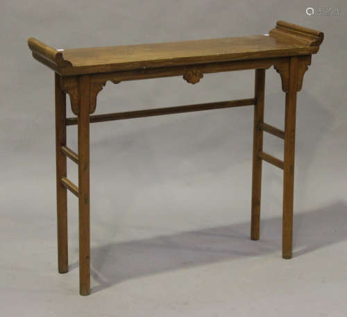 A 19th century Chinese elm altar table, the rectangular top with scroll ends above a carved apron