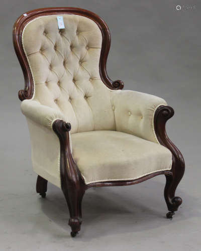A Victorian mahogany carved showframe armchair, upholstered in cream velour, on cabriole legs,