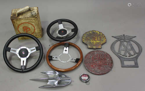 A group of automobilia, including three Mountney steering wheels, a cast aluminium 'Pratts Motor