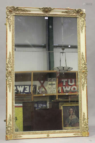 A late 19th century French cream and gilt painted pier mirror with foliate scrolling decoration,