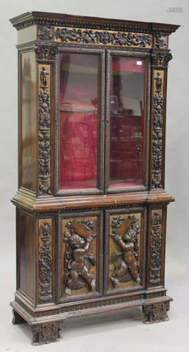 A 19th century Continental walnut and parcel gilded bookcase cabinet, profusely carved with mythical