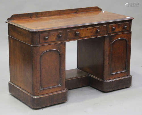 A Victorian mahogany twin pedestal dressing table, the moulded top above three drawers and